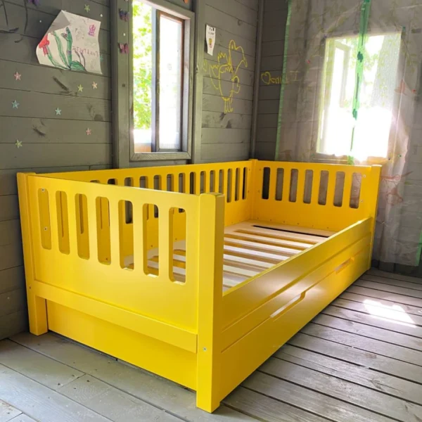 Pat extensibil copii "Iani-Nani" de culoare galbenă, cu loc suplimentar și bariere de protecție, fabricat din lemn masiv.