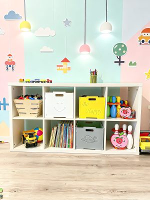 Белая полка для книг и игрушек в детской комнате